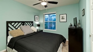 A bedroom with a bed, a ceiling fan, a window, and a dresser. - 19th Hole By Signature Vacation Rentals (Phoenix)