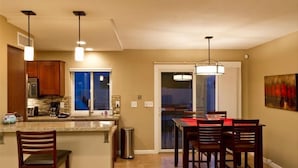 A modern kitchen with a central island, bar stools, and pendant lighting. - 19th Hole By Signature Vacation Rentals (Phoenix)