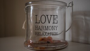 Una taza de vidrio transparente con la inscripción 'LOVE HARMONY RELAXATION'.