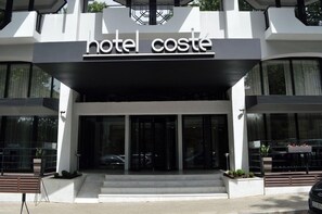 A modern hotel entrance with a prominent sign reading 'hotel coste'. - Hotel Costé (Tbilisi)