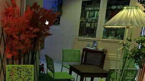 Una habitación con una mesa de comedor, sillas, una lámpara y una planta decorativa.