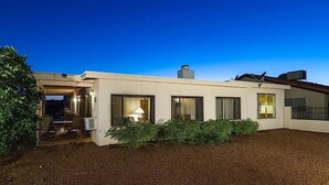 A modern house with a covered porch, large windows, and a well-maintained garden. - Sun Lakes By Signature Vacation Rentals (Chandler)