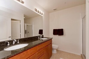 A bathroom with two sinks, a mirror, and a toilet. - The Place To Be By Signature Vacation Rentals (Phoenix)