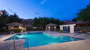 A swimming pool with a tiled deck, surrounded by buildings with outdoor seating areas and a gazebo. - The Keep at La Verne By Signature Vacation Rentals (Phoenix)