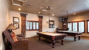 A pool room with two pool tables, a sofa, a lamp, and a television. - The Keep at La Verne By Signature Vacation Rentals (Phoenix)