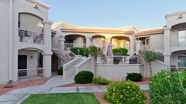 A multi-story residential building with balconies, a central courtyard, and a well-maintained garden. - Sunny Sky Condo By Signature Vacation Rentals (Peoria)