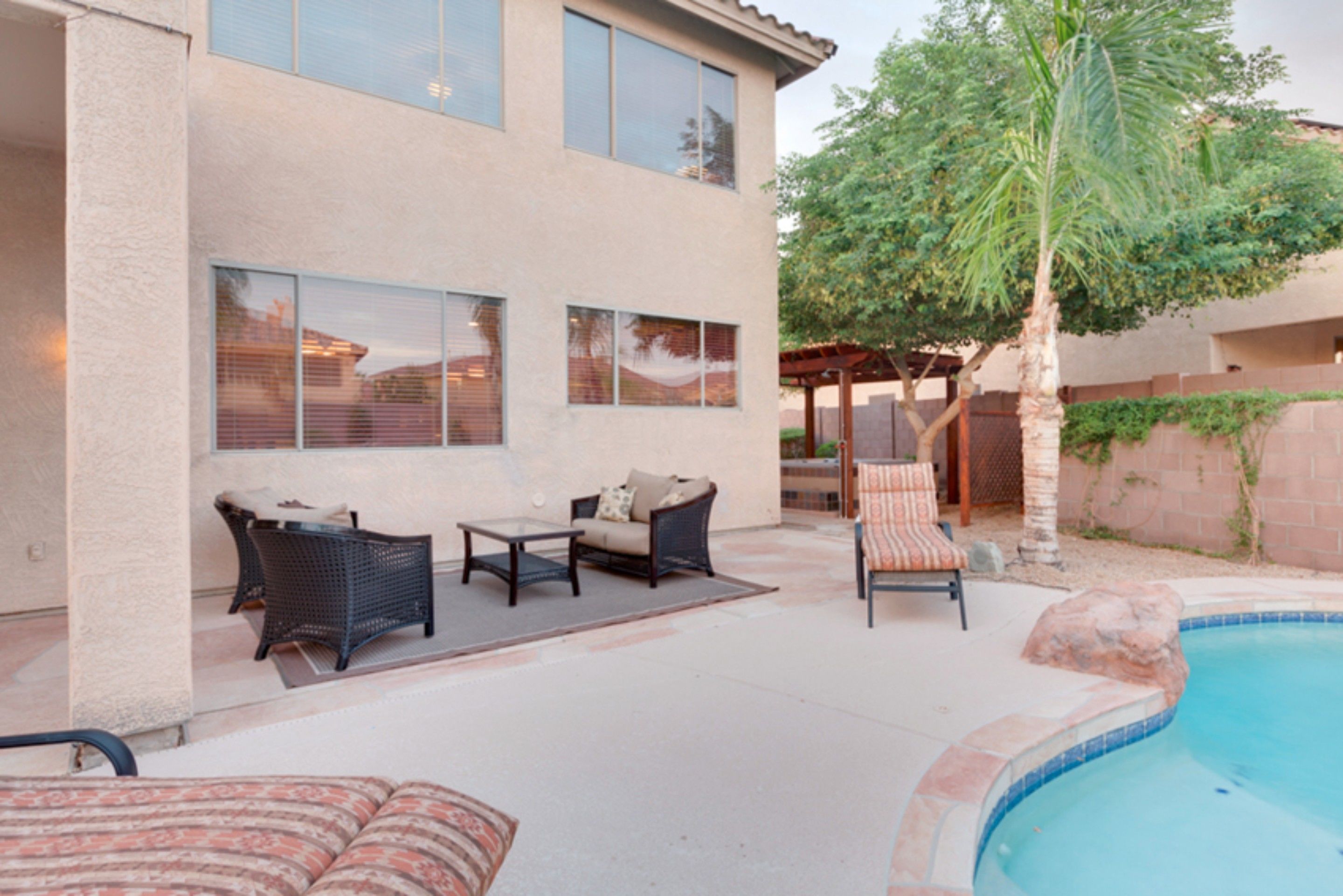 A modern house with a patio, outdoor furniture, and a swimming pool.