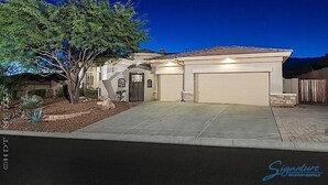 A single-story house with a garage, a driveway, and a tree in the front yard.