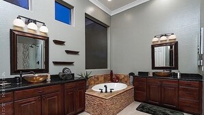 A modern bathroom with a freestanding bathtub, double sinks, and a large mirror.