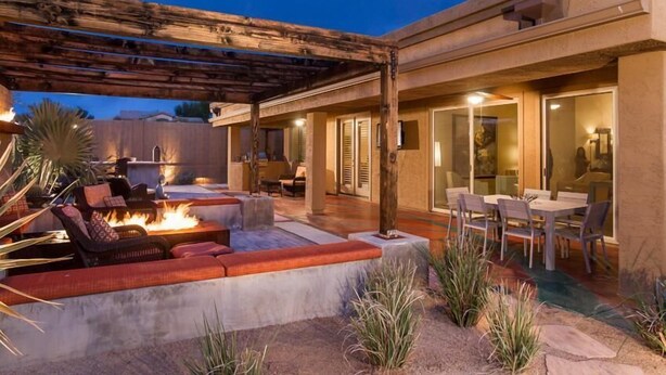 An outdoor patio area with a fire pit, seating, and a covered dining area. - Sonoran Desert Retreat By Signature Vacation Rentals (Scottsdale)