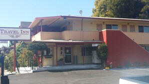 A Travel Inn with a two-story building, a covered entrance, and a parking lot. - Travel Inn (Oakland)
