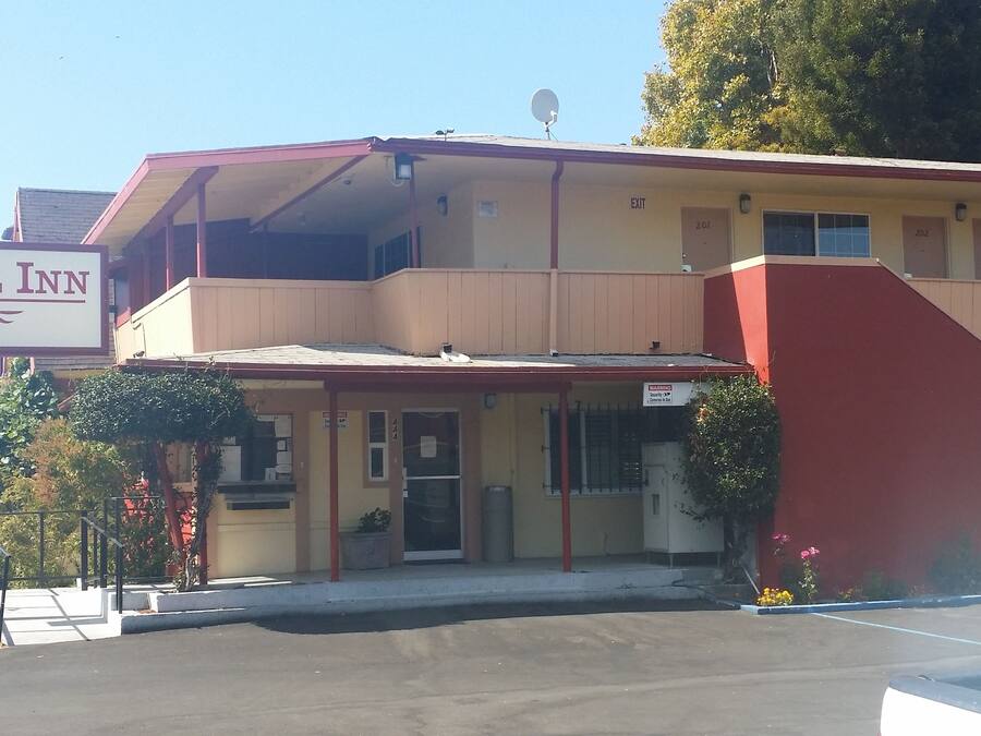 A Travel Inn with a two-story building, a covered entrance, and a parking lot.