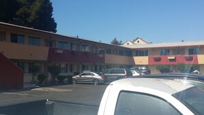 A multi-story hotel with a parking lot. - Travel Inn (Oakland)