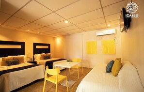 A hotel room with two beds, a small table, and a sofa. - Izalco Hotel & Beach Resort (La Herradura)