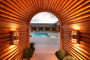 An arched entrance with bamboo walls leading to a pool area. - Desert Hills Paradise By Signature Vacation Rentals (Phoenix)