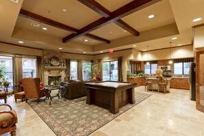 A spacious living area with a pool table, comfortable seating, and a fireplace.