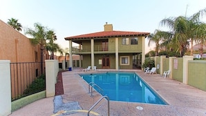 A two-story building with a swimming pool in front. - Casita Escriber By Signature Vacation Rentals (Oro Valley)