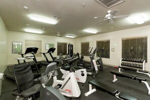 A gym with treadmills, elliptical machines, a bench, and dumbbells. - Bella Vista By Signature Vacation Rentals (Scottsdale)