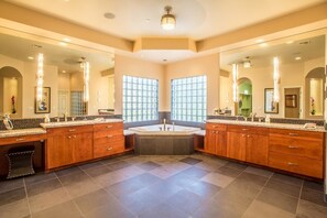 A spacious bathroom with two sinks, a large bathtub, and a vanity with a mirror. - Bella Turquoise By Signature Vacation Rentals (Scottsdale)