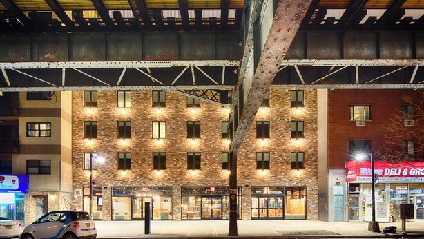 A multi-story building with a brick facade, large windows, and a visible entrance. - Hotel 1080 Brooklyn (Brooklyn)