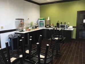 Zona de bar con taburetes, una barra y un microondas.