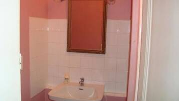 A bathroom with a white sink, a mirror, and a toilet.