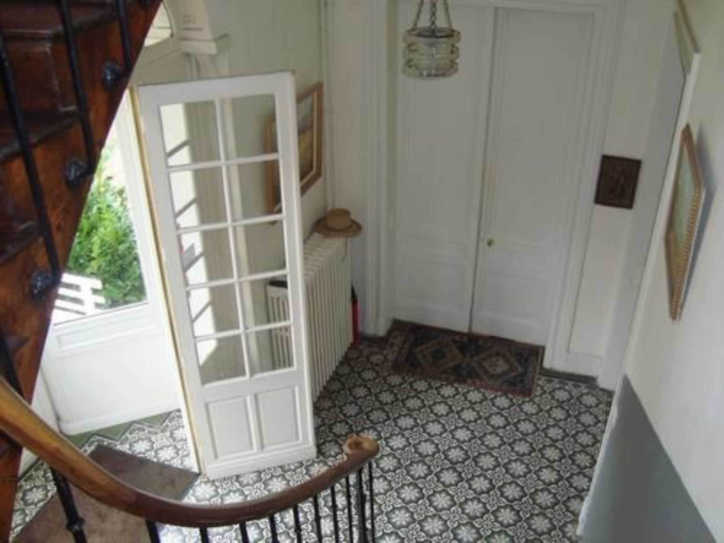 Un escalier menant à une porte surmontée d’un sol à motifs.