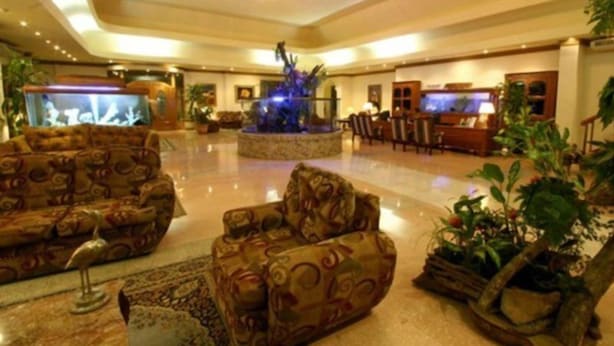 A spacious lobby with patterned sofas, a central fountain, and a television. - Avalon Grand Panama (Panama City)