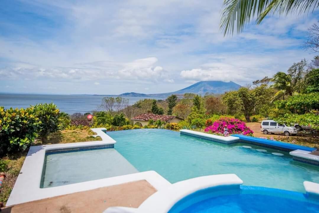 Ein Swimmingpool mit Blick auf den Ozean und einem Berg im Hintergrund.