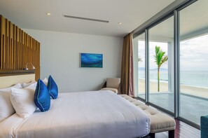 A hotel room with a large bed, a view of the ocean, and a wooden wall panel. - The Ocean Villas (Da Nang Municipality)