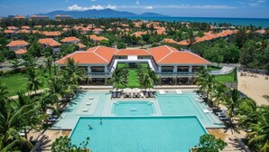 A resort with a central swimming pool, multiple guest villas, and a beach view. - The Ocean Villas (Da Nang)