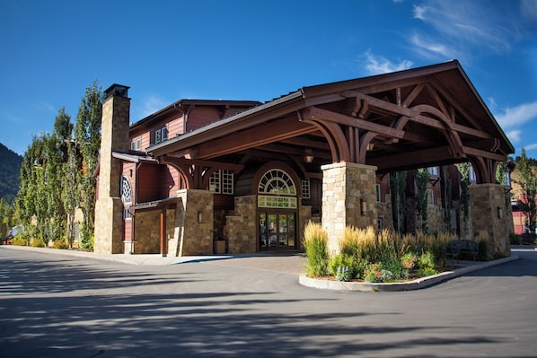 A lodge with a stone facade, a covered entrance, and a mountain backdrop. - Wyoming Inn of Jackson Hole (Jackson)