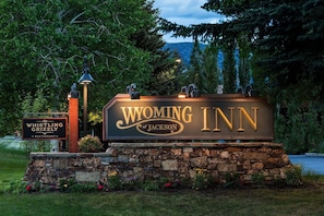 A sign for Wyoming Inn with a stone base and decorative elements.