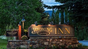 A sign for Wyoming Inn with a stone base and decorative elements. - Wyoming Inn of Jackson Hole (Jackson)