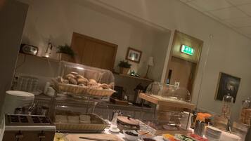 A buffet setup with various food items and a toaster.