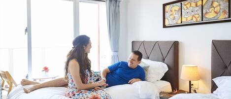 A hotel room with a bed, a nightstand with a lamp, and a window with curtains.