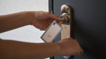Una mà introdueix una clau en la serradura d'una porta.
