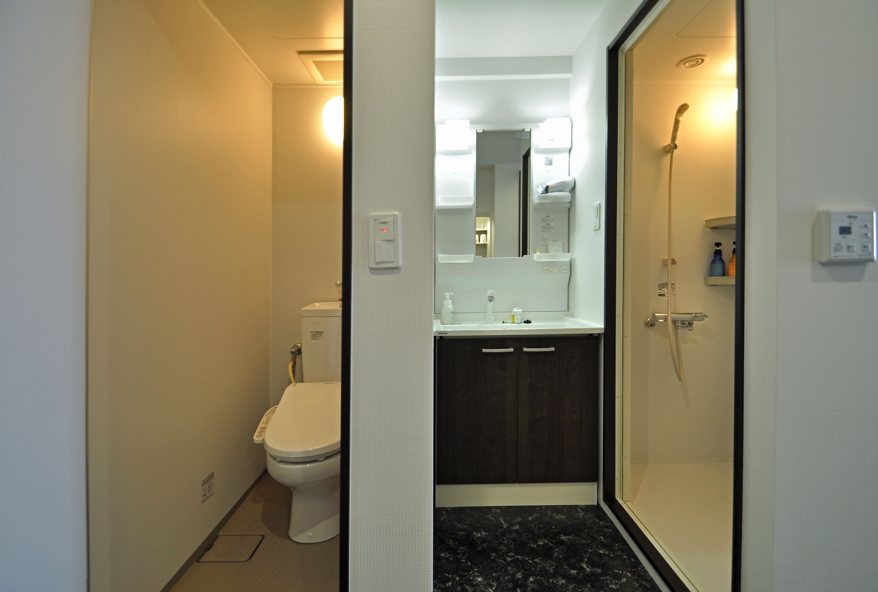 A modern bathroom with a toilet, sink, and shower.