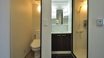 Ein modernes Badezimmer mit Toilette, Waschbecken und Dusche.
