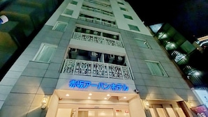 A hotel with a modern facade, featuring a prominent sign in blue and white. - Akasaka Urban Hotel (Tokyo)