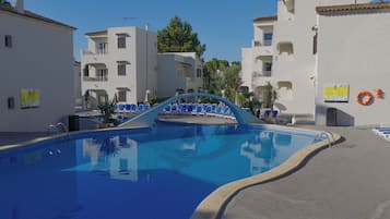Una piscina al aire libre, sombrillas, tumbonas