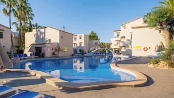 Una piscina al aire libre, sombrillas, tumbonas