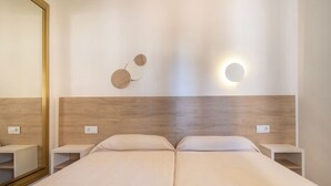 A hotel room with a large bed, bedside tables, a mirror, and a wall-mounted light fixture. - Cabot Club Torre Blanca (Sant Llorenc des Cardassar)