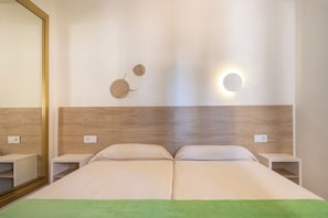 A hotel room with a large bed, bedside tables, a mirror, and a wall-mounted light fixture. - Cabot Club Torre Blanca (Sant Llorenc des Cardassar)