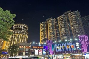 A multi-story building with illuminated signage and a prominent cylindrical structure. - Jinjiang Inn Style (Huizhou West Lake Park DongZhan Store) (Huizhou)