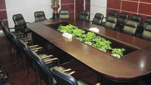 A conference room with a long table, black chairs, and small potted plants. - Ausotel New Tianhe Guangzhou (Guangzhou)