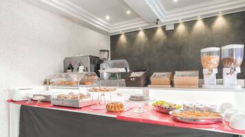 Un'area buffet con diversi cibi e una postazione per il caffè.