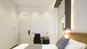 A modern hotel room with a bed, a desk, and a chair. - Hotel Bella Napoli (Naples)