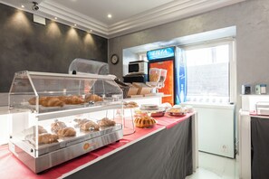 Una vitrina de panadería con diversos productos horneados y una máquina de café.