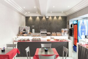 Een ontbijtbuffet met gebak, een koffieapparaat en een koelkast met een Lilia advertentie.
